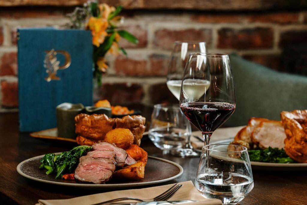 A beef roast dinner and pork roast dinner on a table setting at the Peacock at Owler Bar